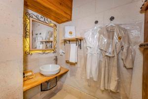 a bathroom with a robe hanging on the wall at Duven Hotel Cappadocia in Uçhisar +125 photos