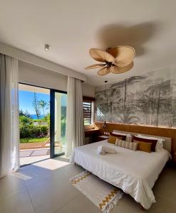 a bedroom with a large bed and a ceiling fan at Exclusive beachfront apartment in Belle Mare
