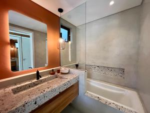 a bathroom with a sink and a tub and a mirror at Exclusive beachfront apartment in Belle Mare +37 photos