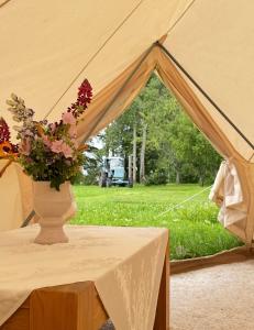 a vase of flowers sitting on a table in a tent at Vallimäe Glamping Otepää in Mägestiku