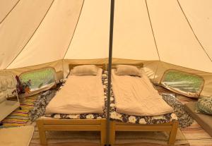 two beds in a tent in a room at Vallimäe Glamping Otepää in Mägestiku