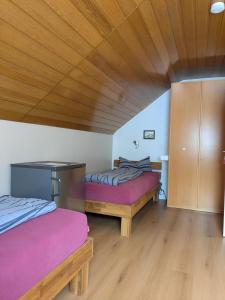 two beds in a room with a wooden ceiling at Ferienapartment Erdmann in Münster +42 photos