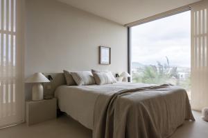 a bedroom with a large bed and a large window at Villa Gara exclusive luxury villa with heated pool in Lajares