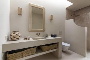 a bathroom with a sink and a toilet and a mirror at Villa Gara exclusive luxury villa with heated pool in Lajares +38 photos