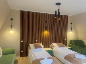a hospital room with two beds and two chairs at Hotel Mimoza in Libusza