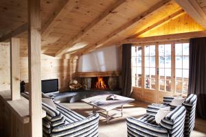 a living room with chairs and a fireplace at Hotel Arc-en-ciel Gstaad in Gstaad
