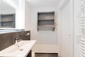a bathroom with a sink and a mirror at Ferienwohnung Stern 3 Scharbeutz in Scharbeutz +23 photos