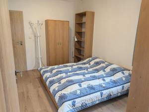 a bedroom with a bed with a blue and white comforter at 386 Apartman in Písek +7 photos