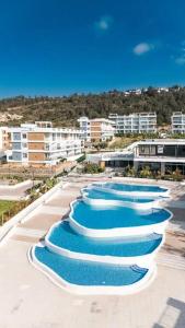 a row of swimming pools in a resort at Luxury Sea & Pool View Apt at Caesar Cliff Esentepe in Perivolia tou Trikomou