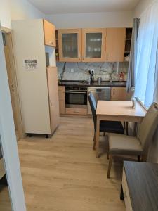 a kitchen with a table and a white refrigerator at 386 Apartman in Písek
