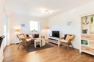 a living room with a couch and a tv at Ferienwohnung Dünenhäuser App. A2 in Scharbeutz