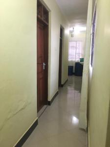 an empty hallway with a wooden door in a building at Amazon half london in Boma la Ngombe