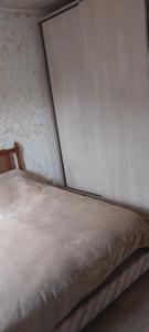 a bed in a bedroom next to a wall at Dvalebi's Marani in Gori