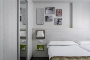 a white bedroom with a bed and a mirror at Estival Cristina in Pas de la Casa