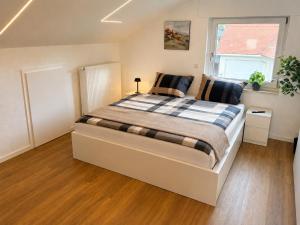 a bedroom with a large bed with a window at Apartment 98 - 2 Schlafzimmer, Balkon & Vogelsbergblick in Hungen