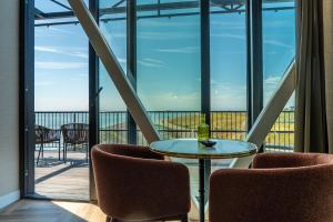 a room with two chairs and a table and a balcony at Punt al Mare in Vlissingen