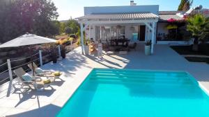 a swimming pool in front of a house at Quinta Luz do Sol in Moncarapacho