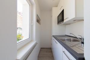 a kitchen with a sink and a window at Ferienwohnung 3 Haus Meeresrauschen - Bungalow in Haffkrug