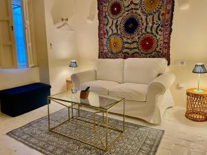 a living room with a white couch and a glass table at Número 9 in Medina Sidonia