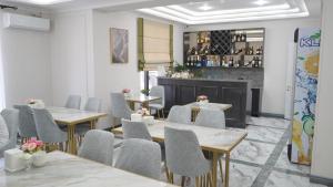 a restaurant with tables and chairs and a bar at Palace&Spa Rooms in Shymkent