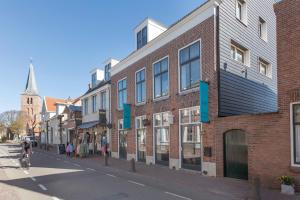 a city street with buildings and a person riding a bike at B&B De Lijsterhof in Domburg
