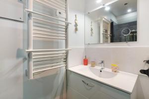 a white bathroom with a sink and a mirror at L'abri des Côtes - Veules les Roses in Pleine-sève +80 photos