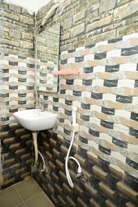 a bathroom with a sink and a brick wall at Hotel Amaravathi Grand in Vijayawāda