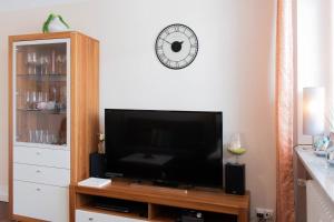 a living room with a flat screen tv on a entertainment center at Ferienwohnung Ostseestübchen in Scharbeutz