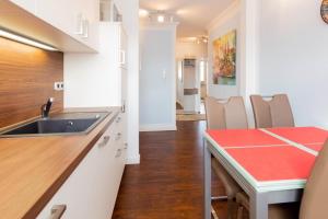 a kitchen with a sink and a table with chairs at Ferienwohnung Ostseestübchen in Scharbeutz