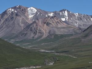 a mountain range with a river in front of it at Gulbubu Guest house in Kochkorka