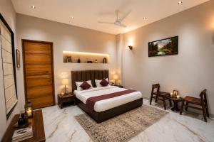 a bedroom with a bed and a table and chairs at Minara Meadows Kasauli in Dharampur