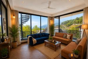 a living room with a blue couch and a large window at Minara Meadows Kasauli in Dharampur