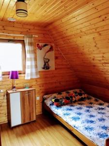 a bedroom with a bed in a log cabin at Domki Relaksowa in Nowęcin