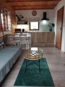 a living room with a table and a kitchen at Domki Relaksowa in Nowęcin +4 photos