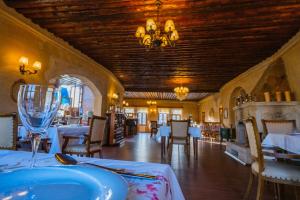 a dining room with tables and chairs and a chandelier at Temenni Evi Cave Hotel in Ürgüp