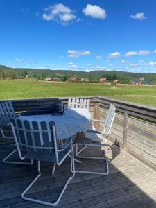 Ein Tisch und zwei Stühle stehen auf einer Terrasse in der Unterkunft Låbbyn15 in Årjäng