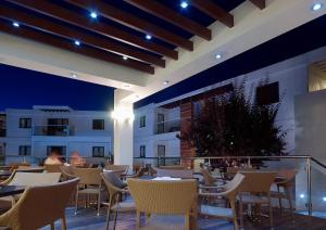 a restaurant with tables and chairs on a balcony at Minos Village in Agia Marina Nea Kydonias +17 photos