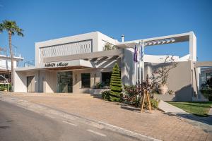 a large white building on a street at Minos Village in Agia Marina Nea Kydonias