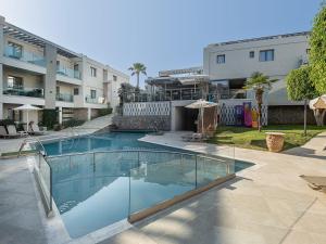a swimming pool in front of a building at Minos Village in Agia Marina Nea Kydonias