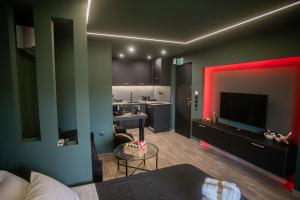 a room with a kitchen and a living room with red lighting at Skyline suite studio in Larisa