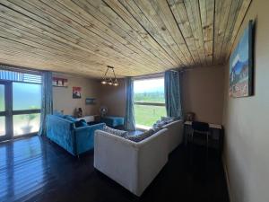 a living room with two couches and a large window at I love Amboseli in Kimana