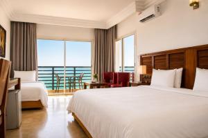 a hotel room with a large bed and a balcony at Hotel Buenavista Dakhla in Dakhla