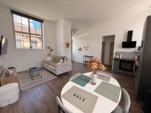a living room with a table and a couch at Le Côté Cour in Dole