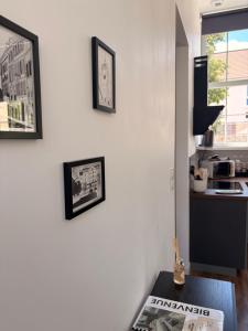 a kitchen with two pictures on the wall and a table at Le Côté Cour in Dole