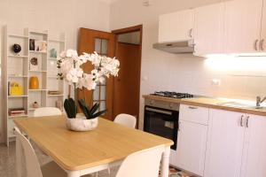 a kitchen with a table with a vase of flowers on it at Guest House Scarlatti in Battipaglia