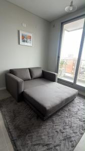 a couch in a living room with a large window at Departamento Excelente Ubicación - Torre Fenix in Santa Fe +5 photos