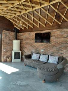 a living room with a couch and a brick wall at Villa Alpina Borsec in Borsec