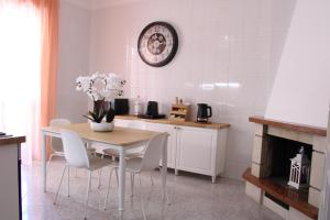 a kitchen with a table and chairs and a clock on the wall at Guest House Scarlatti in Battipaglia +13 photos