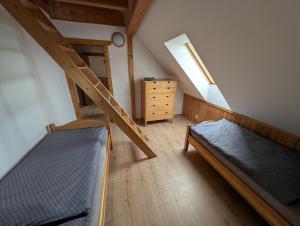 a attic room with two beds and a staircase at Chalet Kočí in Kořenov