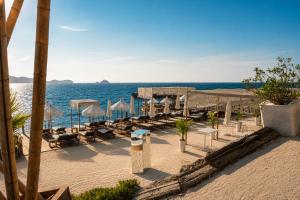 a beach with chairs and umbrellas and the ocean at Palmalife Bodrum Resort & Spa in Yalıkavak